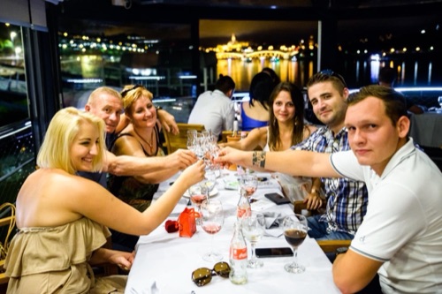 Baráti társaság koccint egy esti rendezvényen a hajón